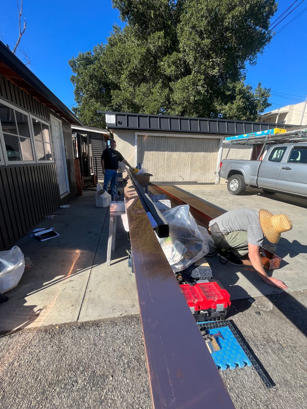 Rick's Raingutter Service crew fabricating a long custom gutter run on-site