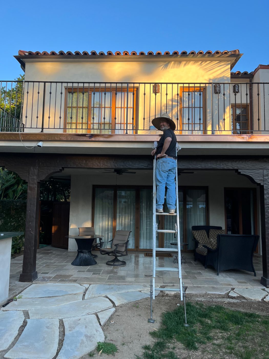 Rick Mooney installing custom copper gutters on a fine Los Angeles home